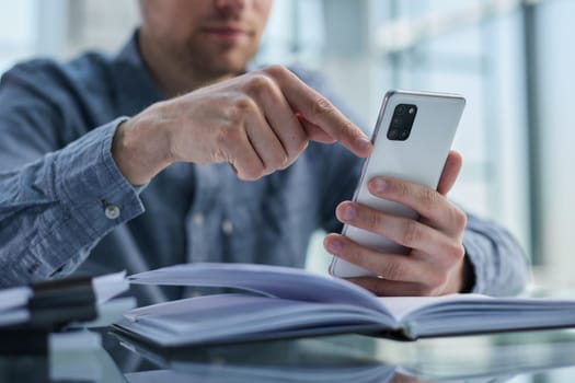businessman professional executive holding mobile working at desk with smartphone.