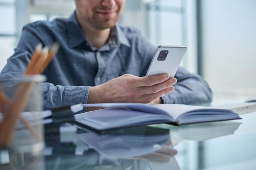 businessman professional executive holding mobile working at desk with smartphone.