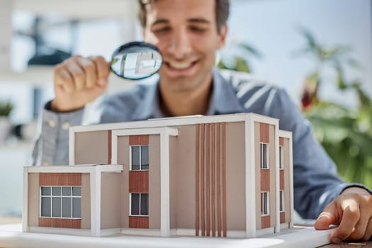 the guy looks at the layout of the house through a magnifying glass