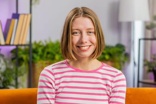 Portrait of happy calm young pretty woman at home couch smiling friendly glad expression looking at cameradreaming resting, relaxation feel satisfied concept good news, celebrate win. Girl in room