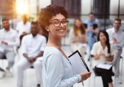 Selective focus of young businesswoman together with interracial colleagues during seminar