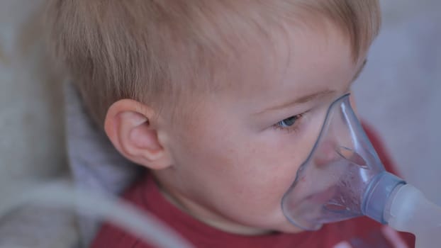 Funny boy breathing through an inhaler mask