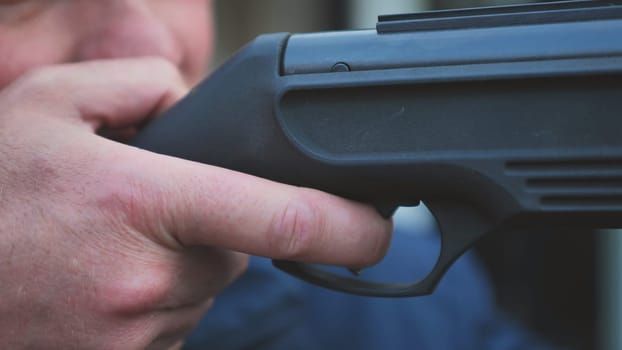 A man firing an air gun. Close-up of her hands
