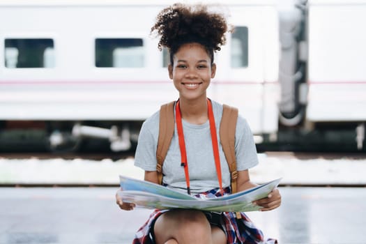 Asian teenage girl african american traveler dressed in casual wear holding map and searching right direction of route