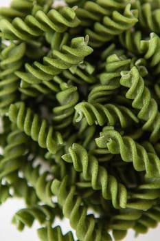 Raw green fusilli pasta, natural based on spinach and spirulina. Delicious and healthy food. Close-up