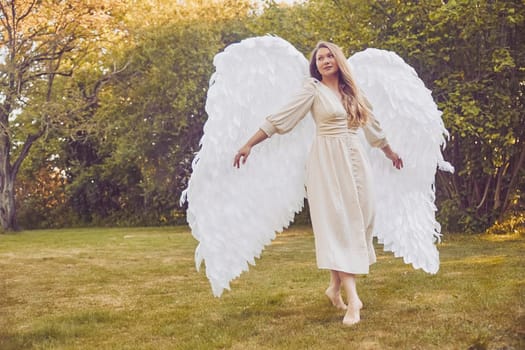 Olstrup, Denmark, June 6, 2023: Beautiful girl dressed as an angel in the garden