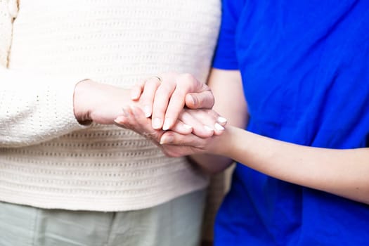 Doctor shaking hands with a senior patient at home. Nurse handschaking with an old lady. Close up of a helping hand.