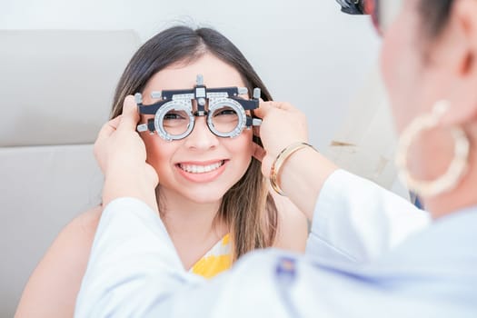 Vision check with optometrist trial frame on patient. Doctor checking vision of patient with trial frame in ophthalmology clinic