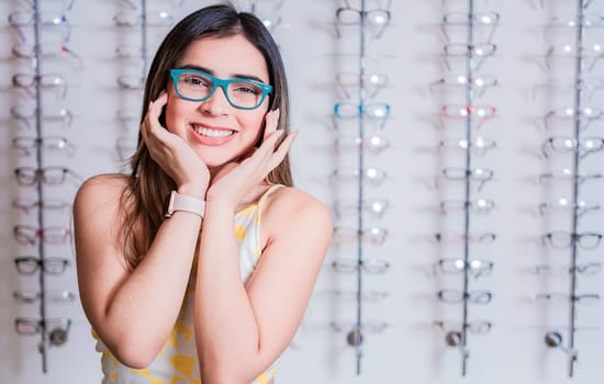 Smiling happy girl in eyeglasses with store eyeglasses background, Portrait of happy girl in glasses in an eyeglasses store