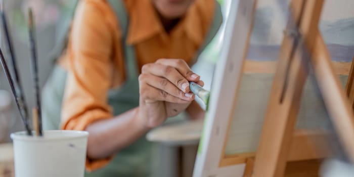 Close up of african american male painter at work painting on canvas in art studio. creation and inspiration at an artists painting studio.