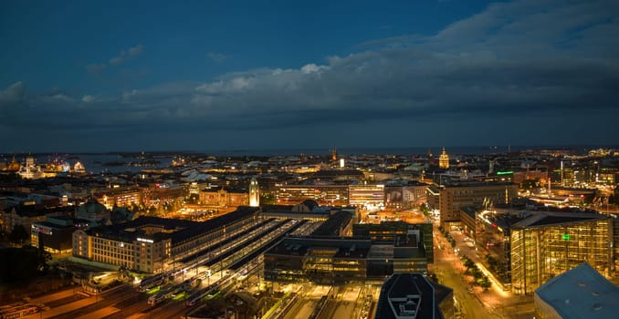 Central train station and city lights glow on summer night in Helsinki. High quality photo