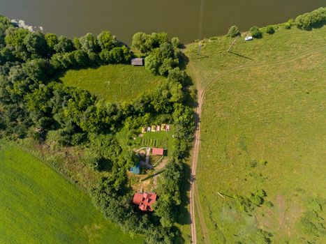 Top view of camp of tourists with tents on the river bank.