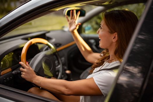 Young pretty woman driver driving a car and arguing with someone.