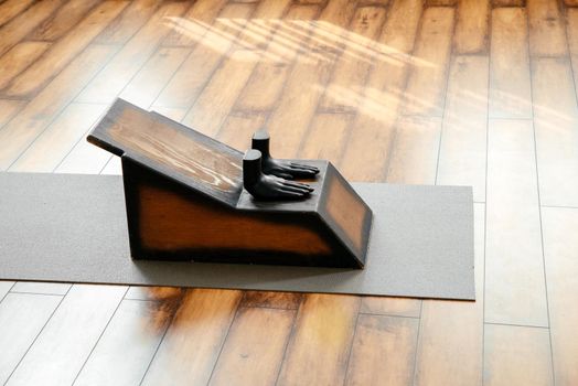 Yoga proffesional equipment, wooden bench and stool on the floor in yoga studio. Yoga and health concept