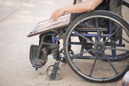 close up old man sell lottery sitting on the wheelchair