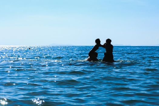 silhouette image group young people are playing on the sea