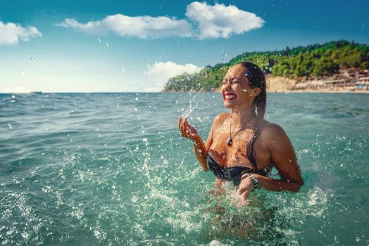 Beautiful young woman having fun and enjoying in the sea, on the beach. 