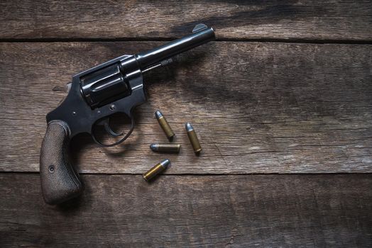 Gun and ammunition on wooden table. top view