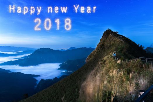 Happy new year 2018 written with Sparkle firework on fireworks with dark background, celebration concept