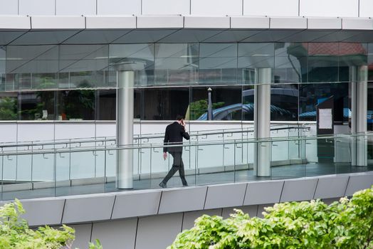 businessman using mobile phone and walk to the tower