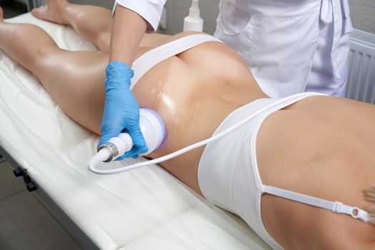 Hardware cosmetology. Body care. Spa treatment. Ultrasound cavitation body contouring treatmentWoman getting anti-cellulite and anti-fat therapy in beauty salon.