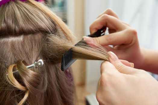 Hairdresser styling hair of a client in a beauty salon