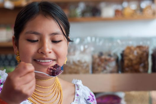 indigenous woman looking at a piece of cake before eating it with pleasure. High quality photo