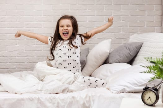 cute little child girl wakes up from sleep in bed in the morning