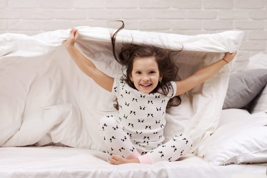 happy morning baby in bed. child dabbles in bed
