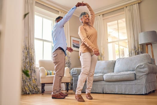 Retirement, romance and dance with a senior couple in the living room of their home together for bonding. Marriage, love or fun with an elderly man and woman dancing in the lounge of their house.