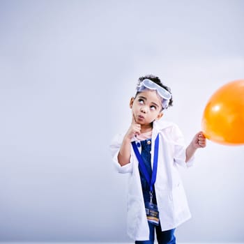 Child, thinking and balloon science in studio with .hand on chin, goggles and idea. African kid student with solution or problem solving, education or fun biology experiment on a white background.