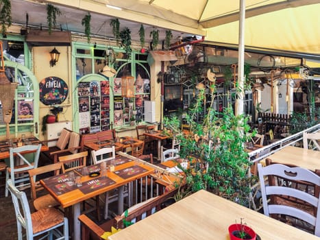 Day view of the empty traditional outdoor seating area of taverns with colorful chairs, tables and vintage decoration at the historic Bit Bazaar area.