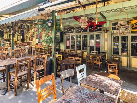 Day view of the empty traditional outdoor seating area of taverns with colorful chairs, tables and vintage decoration at the historic Bit Bazaar area.