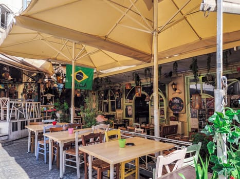 Day view of the empty traditional outdoor seating area of taverns with colorful chairs, tables and vintage decoration at the historic Bit Bazaar area.