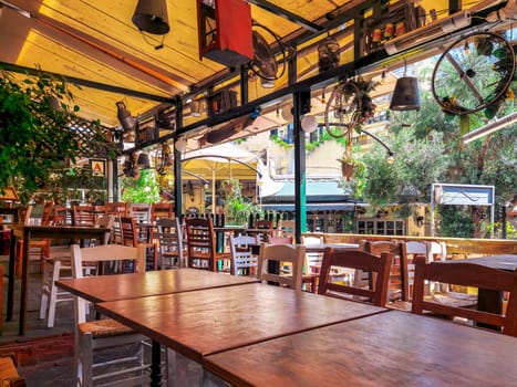 Day view of the empty traditional outdoor seating area of taverns with colorful chairs, tables and vintage decoration at the historic Bit Bazaar area.