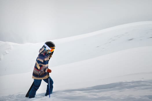 Portrait of beautiful woman with ski and ski suit in winter mountain.