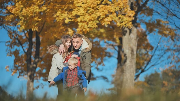 A young, happy family in the park sprinkled with leaves