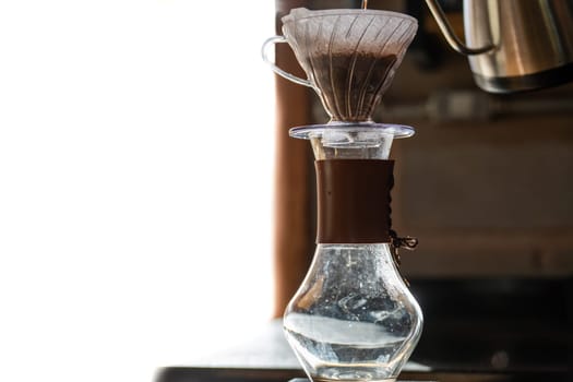 Watch the slow process of coffee being prepared the traditional way, with a filter and simple water, in a transparent container perfect for adding text.