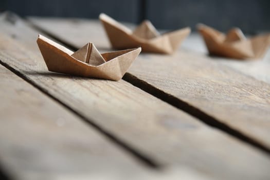 Paper boats on a vintage background. Origami paper boat.