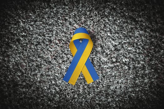 yellow and blue ukraine ribbon on grey stone background. concept needs help and support, truth will win