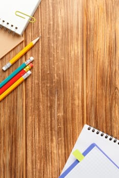 Open spiral notebook with a pencil on a wooden background. Study desk. Flat lay. Back to school concept. Top view.