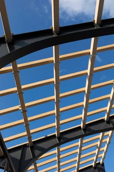 Shed, Roof Construction, Process Of Building A Wooden Canopy From Boards And Structural Steel Beam, No People. Blue Sky On Background. Engineering. Vertical Plane,