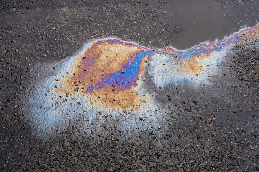 Leaked petroleum products on the roadway. Oil stains on wet asphalt.