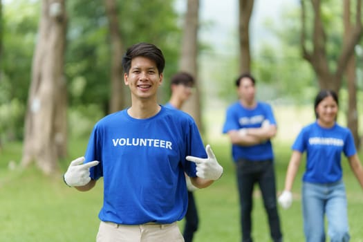 Young Asian Volunteers with garbage bags cleaning park area. Ecology, Charitable organization concept.