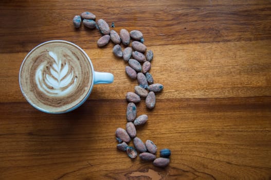 composition of a cup of coffee and some coffee beans in the shape of an s. High quality photo