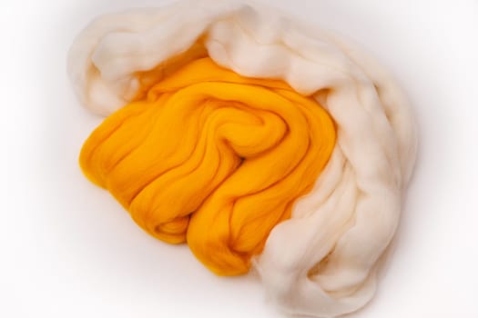 White and yellow merino wool for felting on a white background.