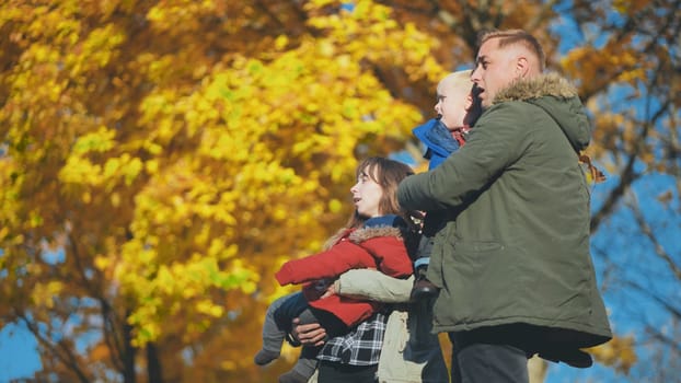 A young, funny family with kids in the park in the fall