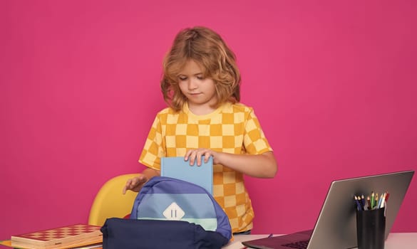 Kid boy from elementary school with book. Smart caucasian school boy kid pupil going to school. School child isolated on red pink studio background. Concept of education and learning