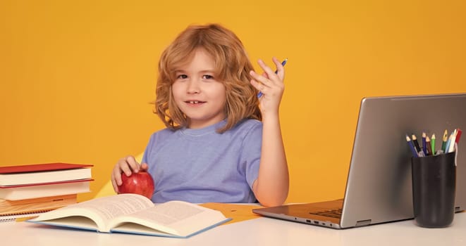 School child studying in classroom at elementary school. Kid studying on lesson on yellow isolated background