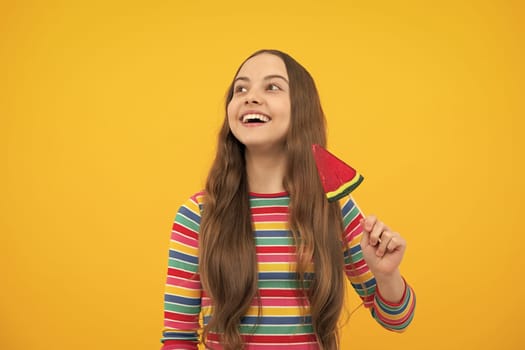 Teen girl hold lollipop caramel on yellow background, candy shop. Teenager with sweets suckers